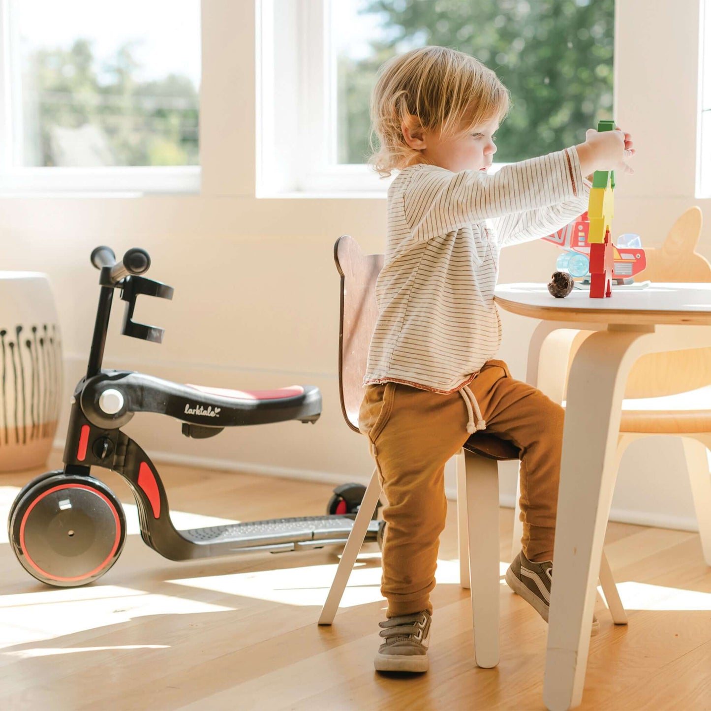 toddler sitting near red larktale scoobi playing with toys